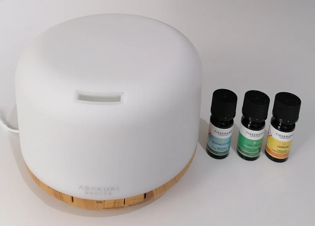 asakuki diffuser alongside three tisserand essential oil bottles - eucalyptus, tea tree and lemon