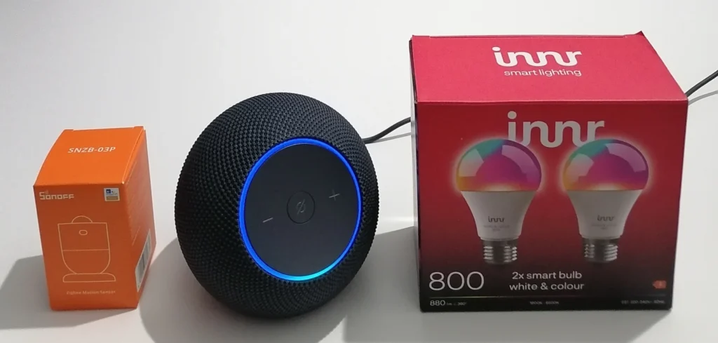 echo dot max with blue ring light between sonoff snzb-03p box and innr smart bulb box