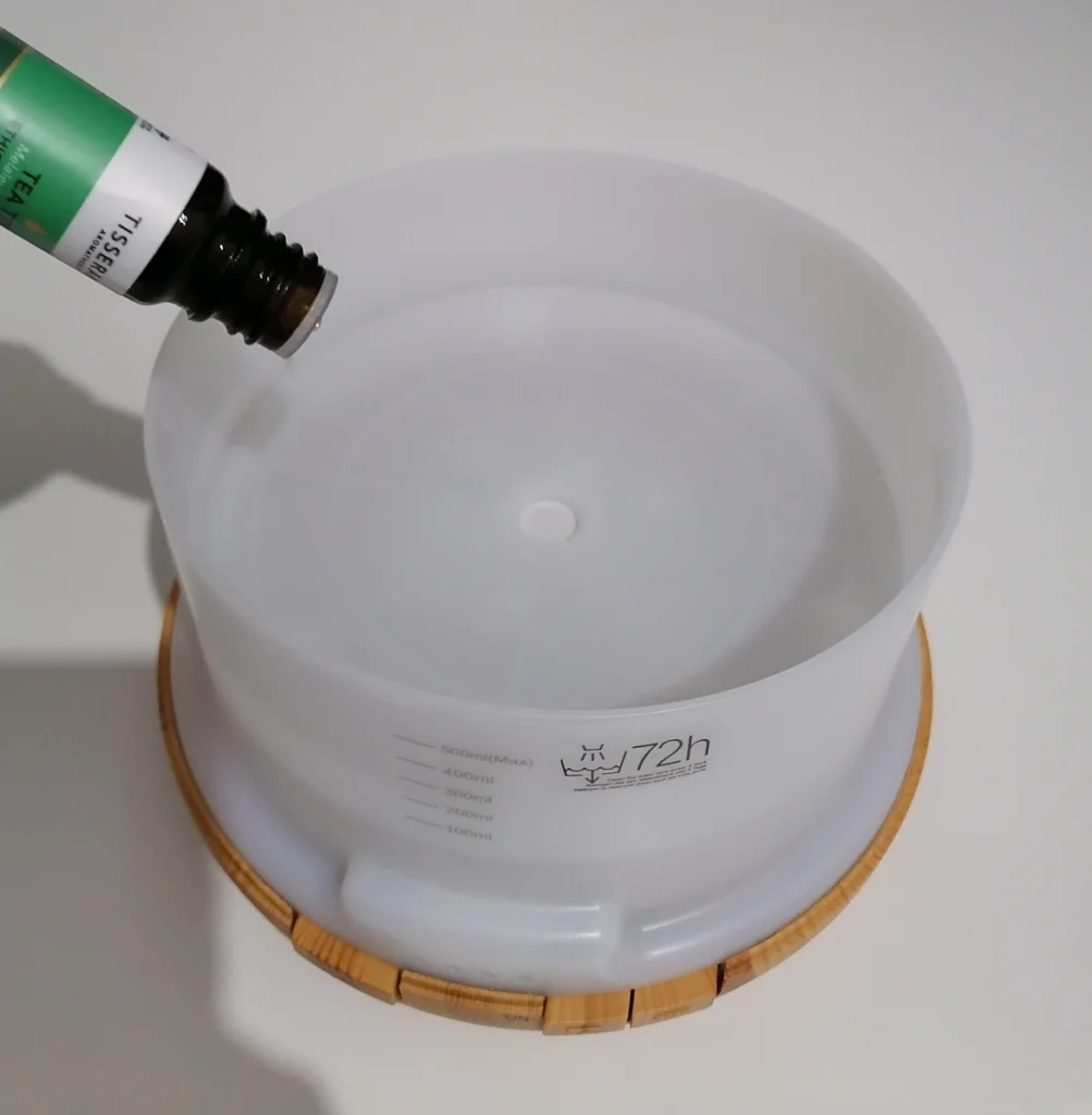 adding tisserand tea tree essential oil drops into the asakuki diffuser water tank