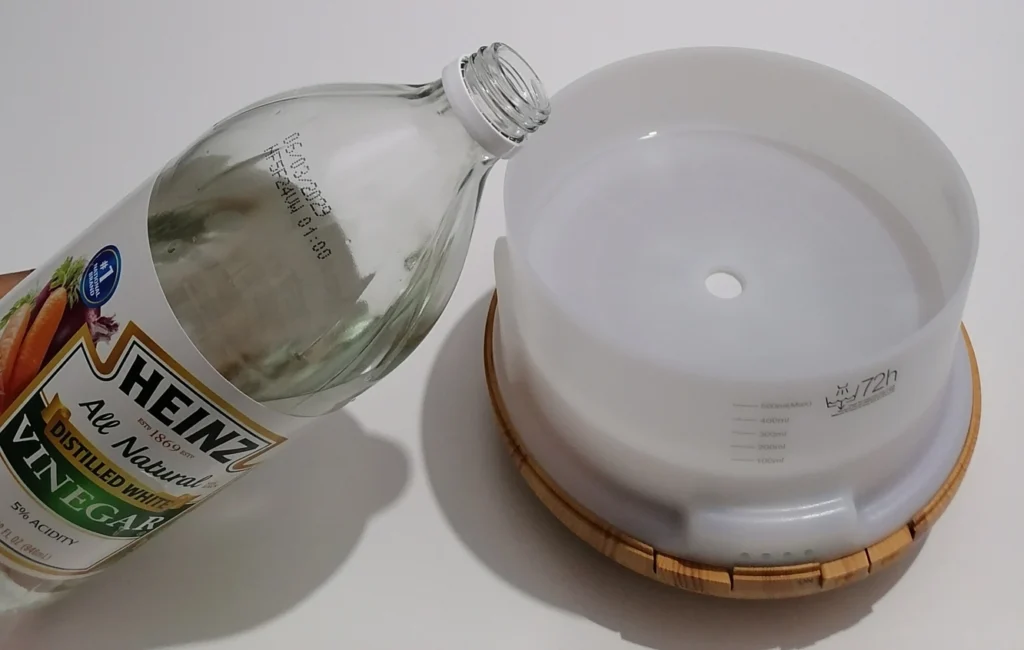heinz white vinegar being added to asakuki diffuser water tank for weekly cleaning