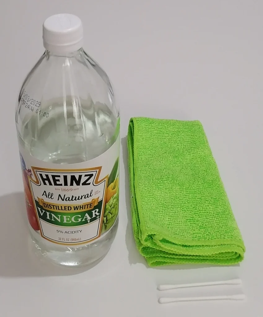 heinz white vinegar bottle, green microfibre cloth and cotton swabs for cleaning an essential oil diffuser