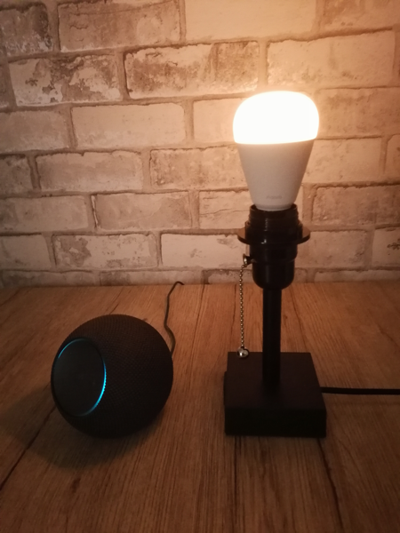 aqara t2 smart bulb glowing warm white in a lamp next to an echo dot max